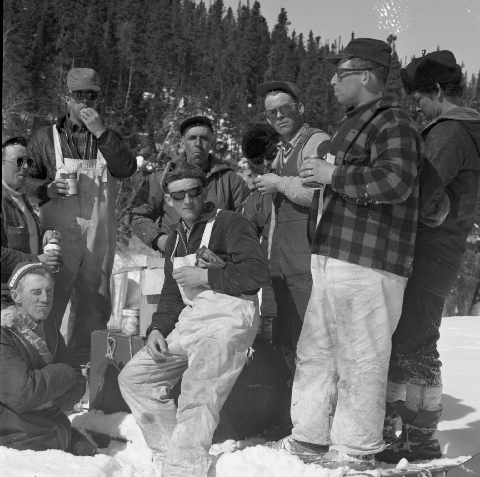 Les participants à la course en cométique se reposent et discutent en prenant un repas, mars 1967.