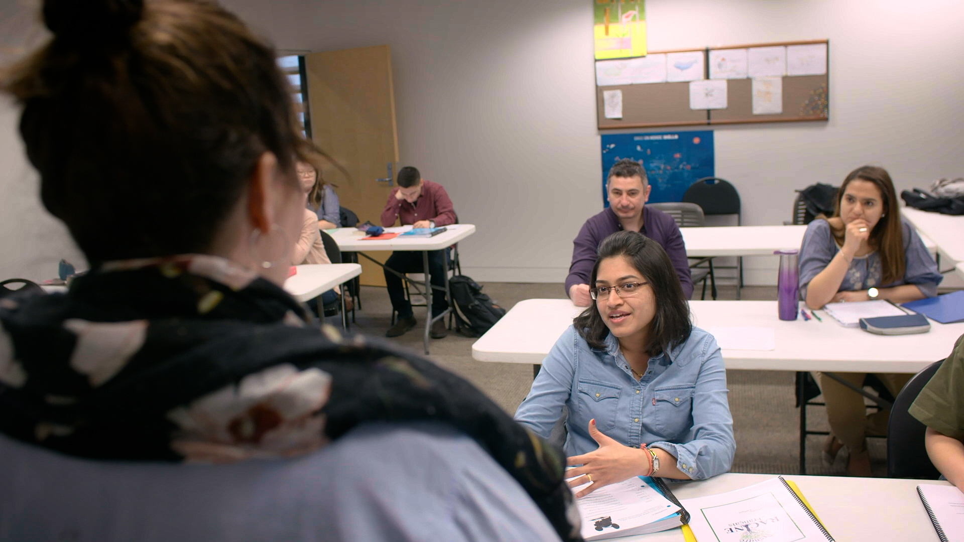 Adultes assis dans une classe avec enseignante à l.avant.