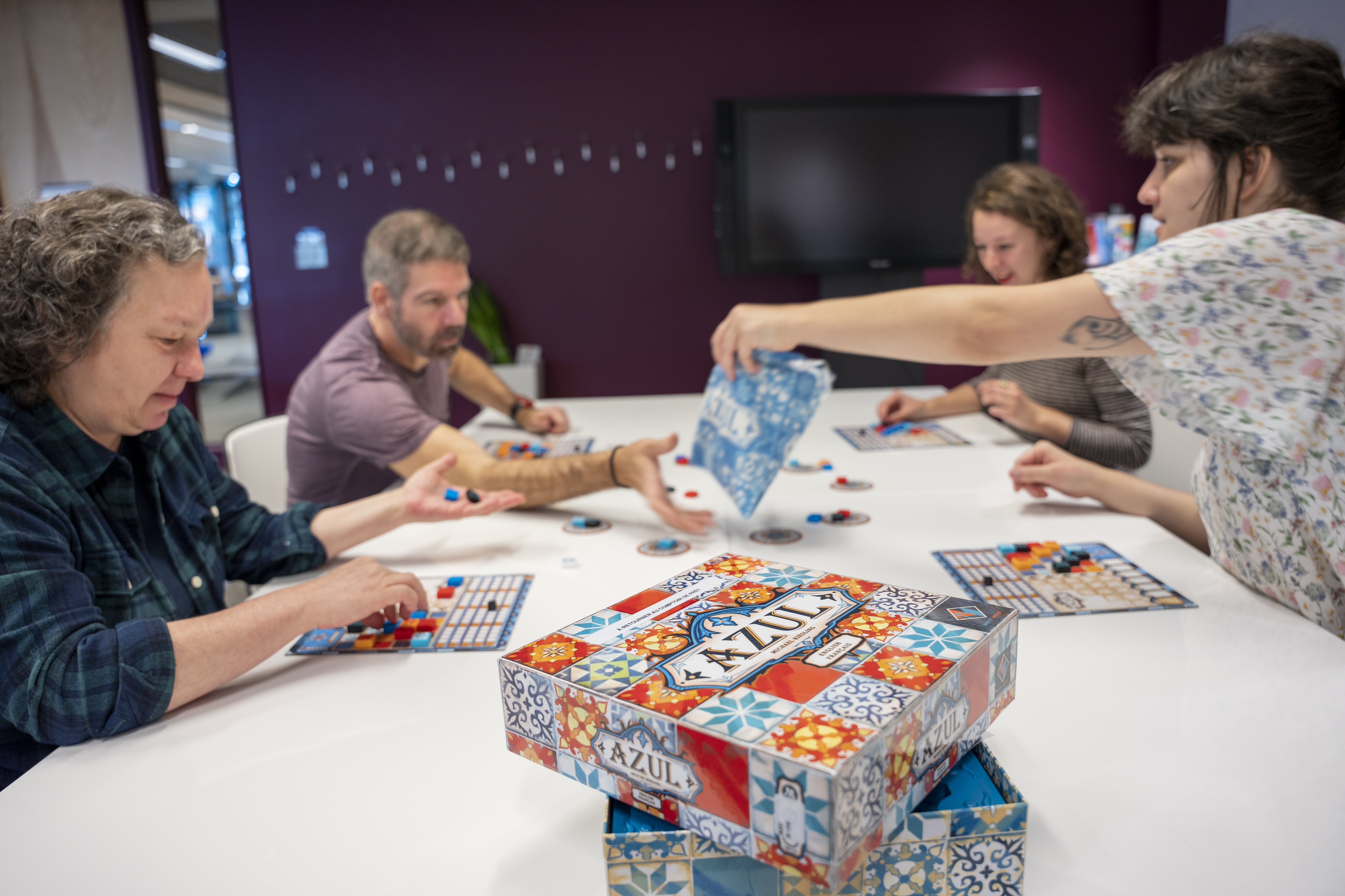 Quatre personnes jouent à un jeu de société.