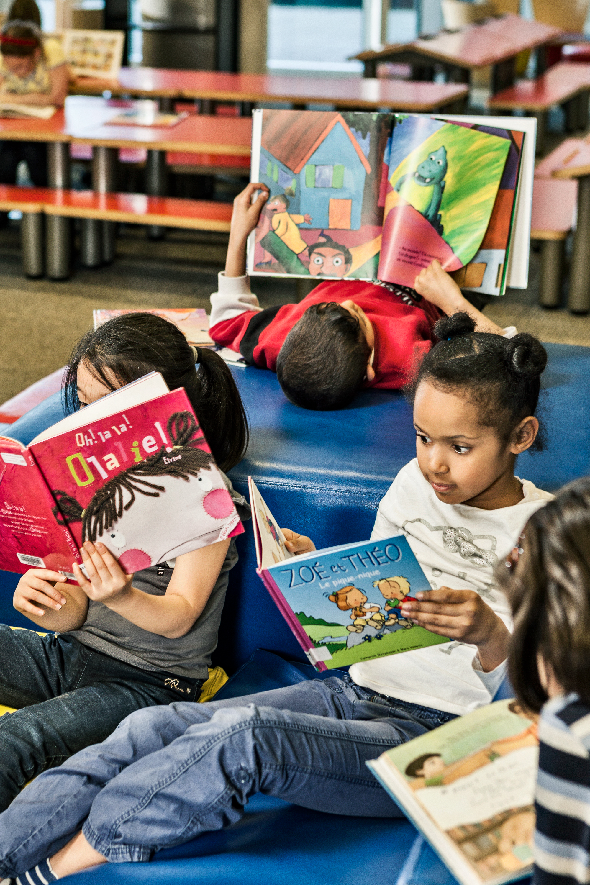 Enfants qui lisent des livres à l'Espace Jeunes de la Grande Bibliothèque.