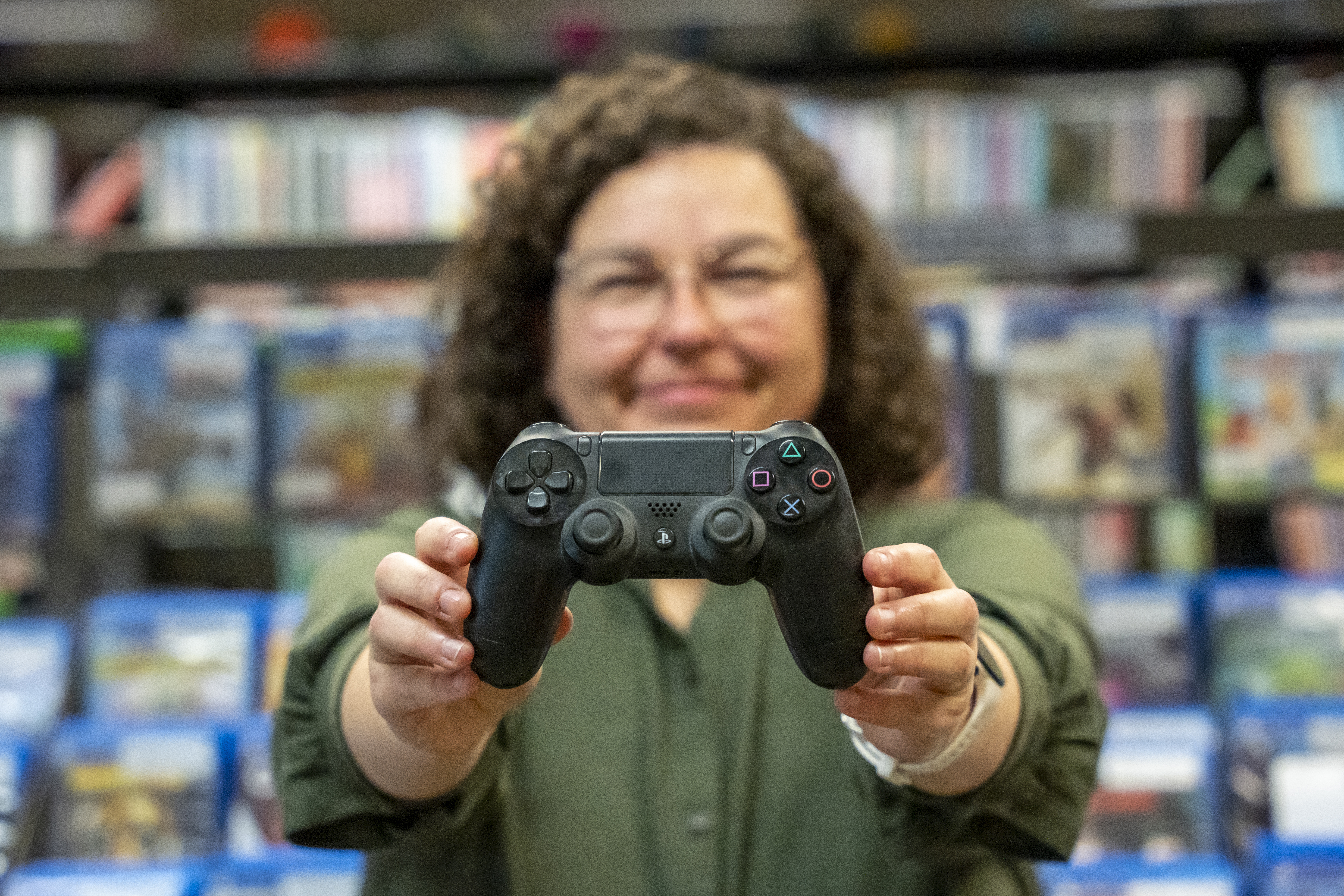 Femme tenant une manette de jeu vidéo.