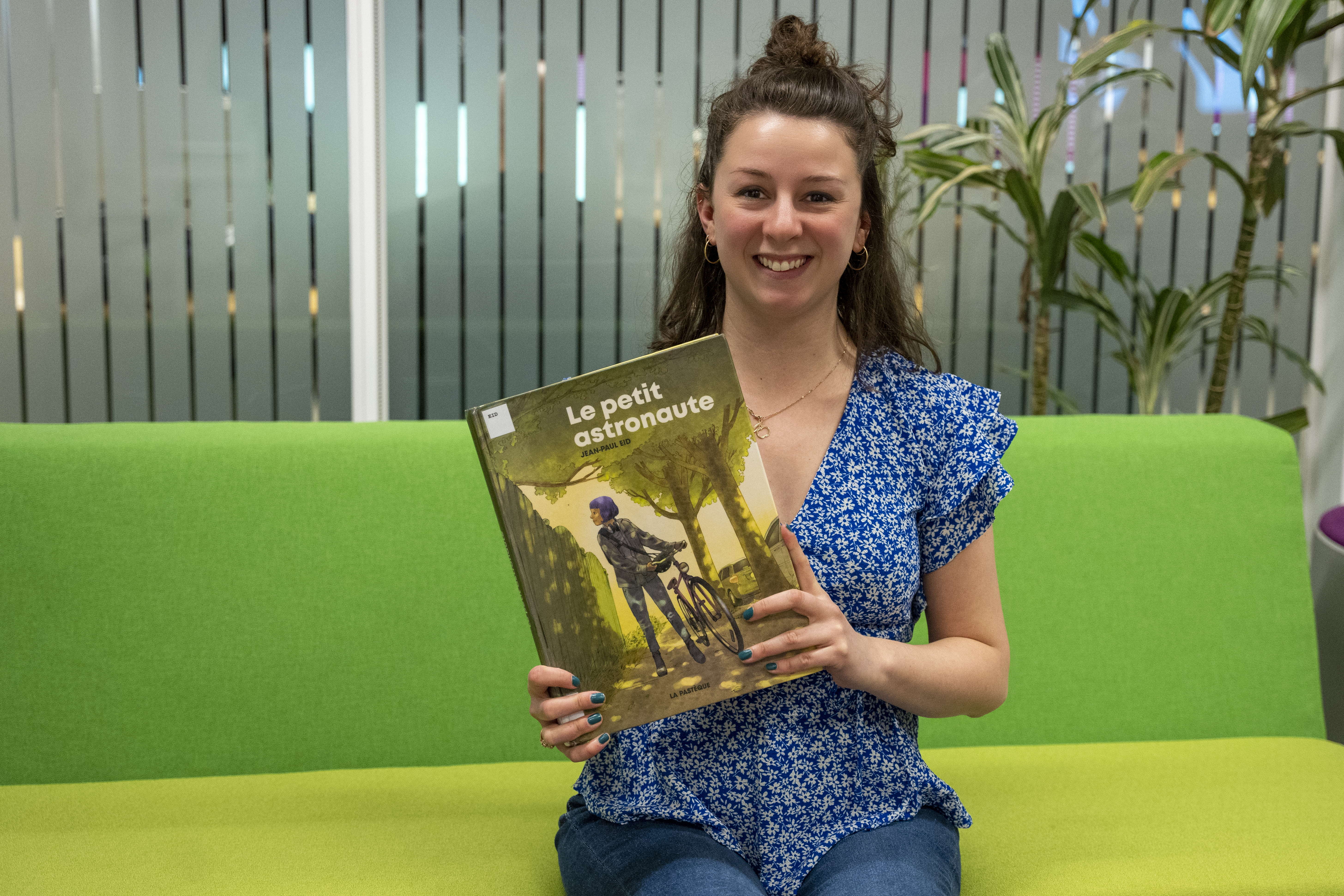 Une femme montre la bande dessinée « Le petit astronaute ».