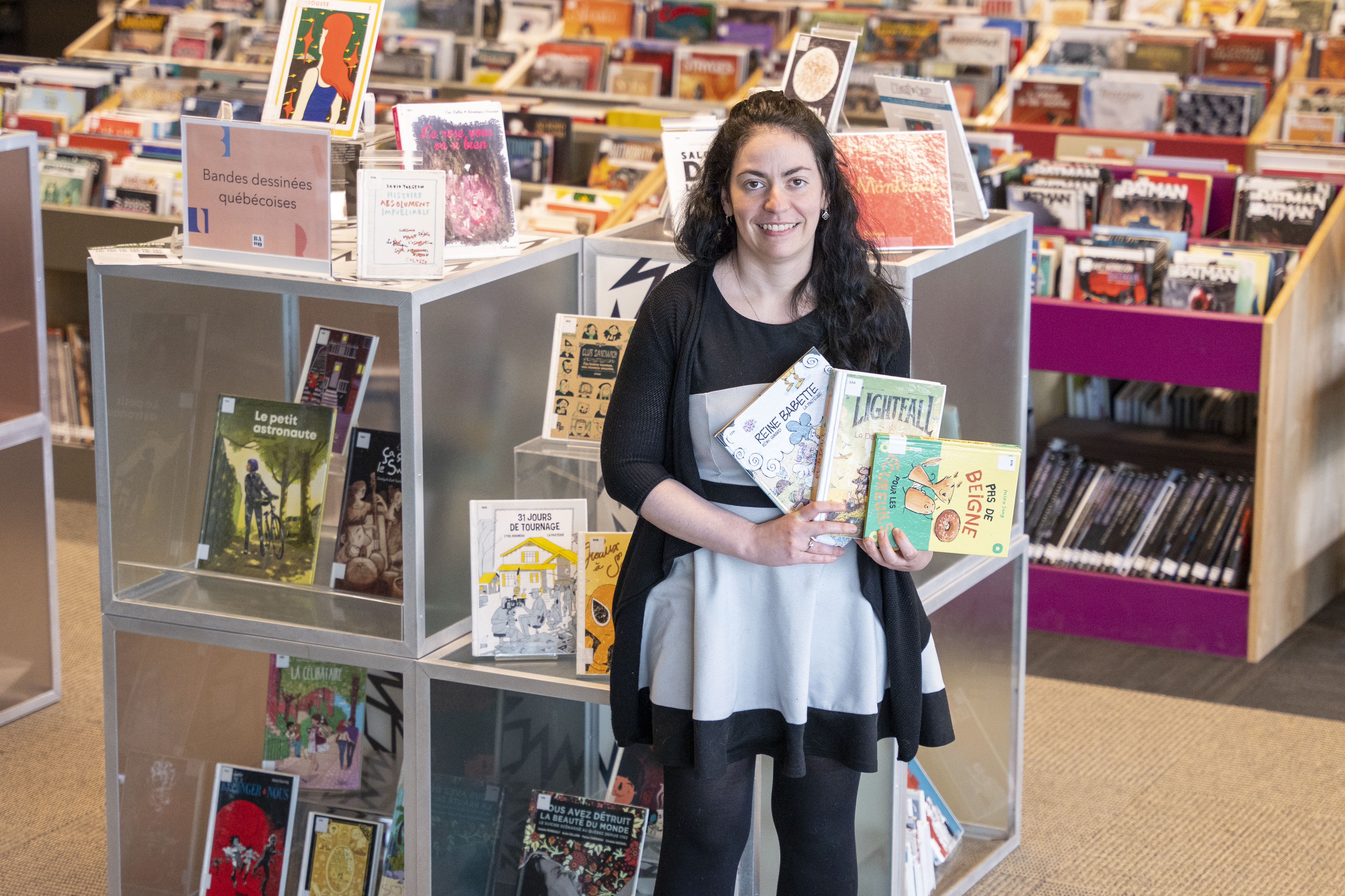 Femme tenant des bandes dessinées dans ses mains, à la Grande Bibliothèque.