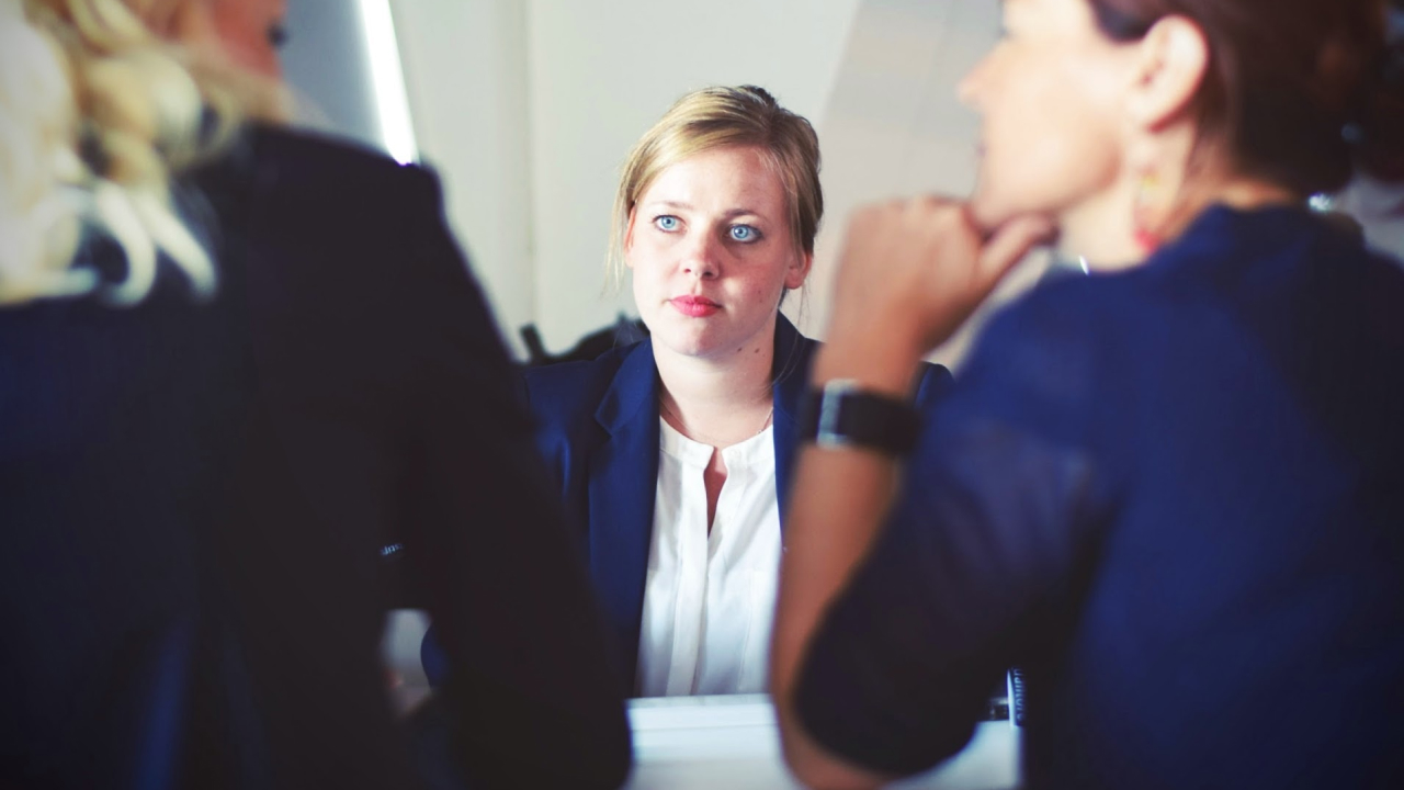Trois femmes d'affaires discutent autour d'une table.