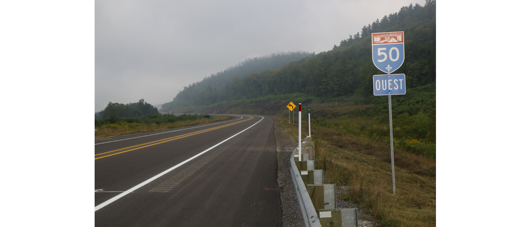 Autoroute. Panneau de signalisation indiquant qu'il s'agit de la 50 ouest. Nuageux.