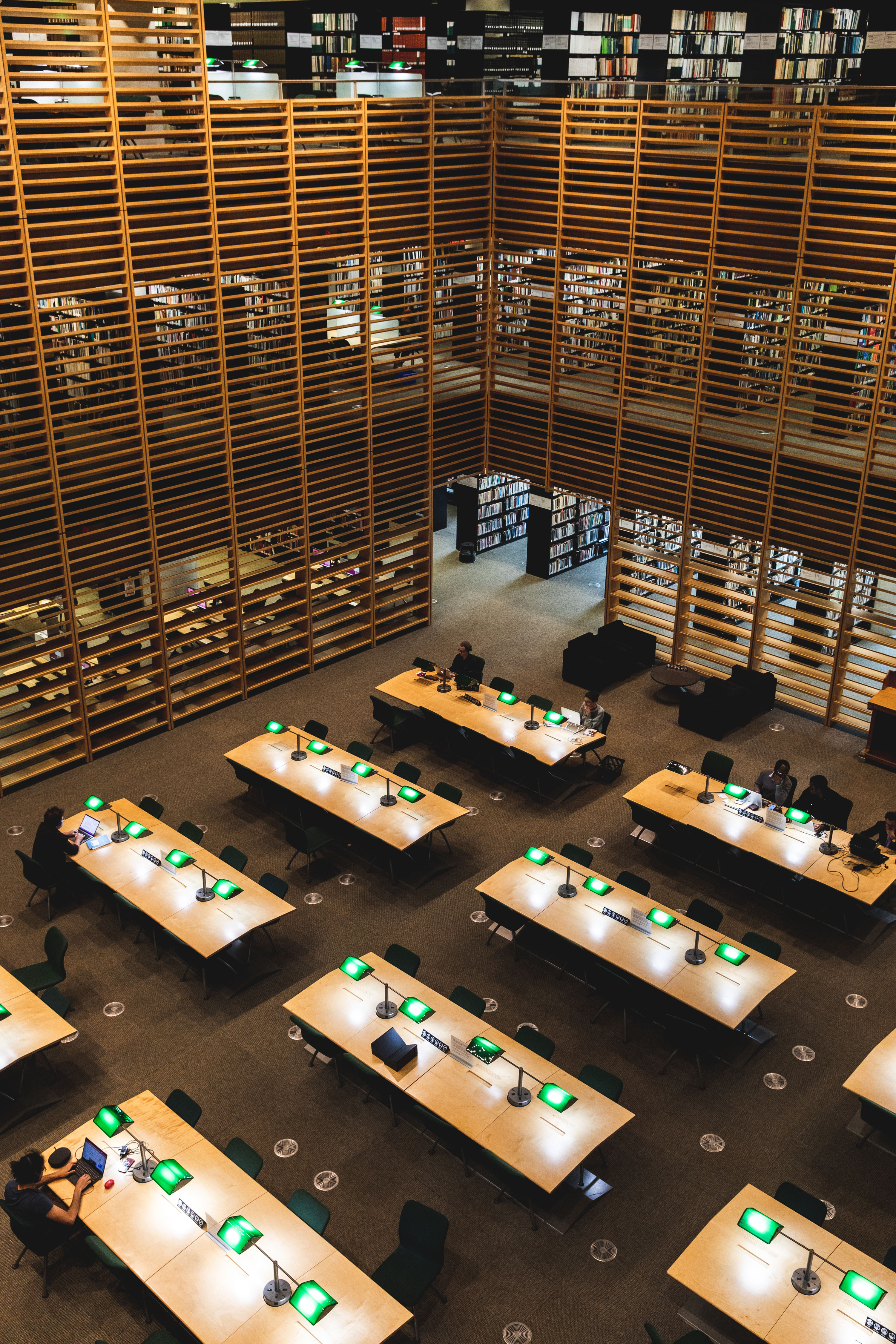 Tables d'une salle de lecture aux murs boisés.