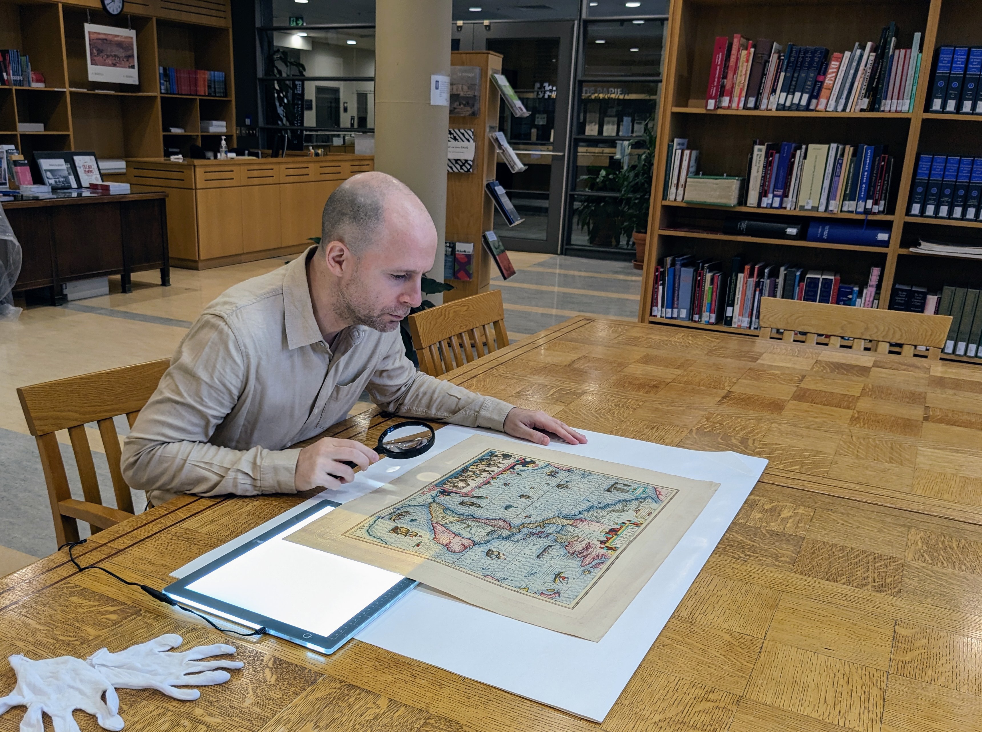 Photographie d’Alban Berson, examinant une carte géographique