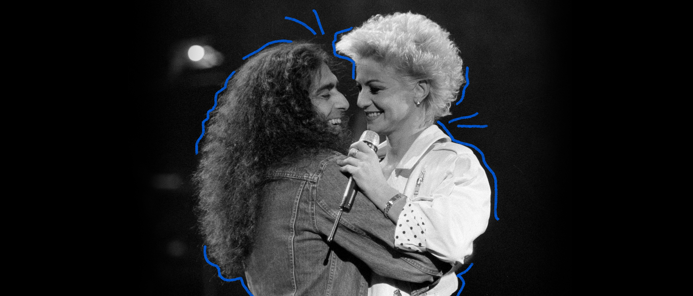 Photo d'archives en noir et blanc de Gerry Boulet et Marjo chantant sur scène en se prenant par les bras