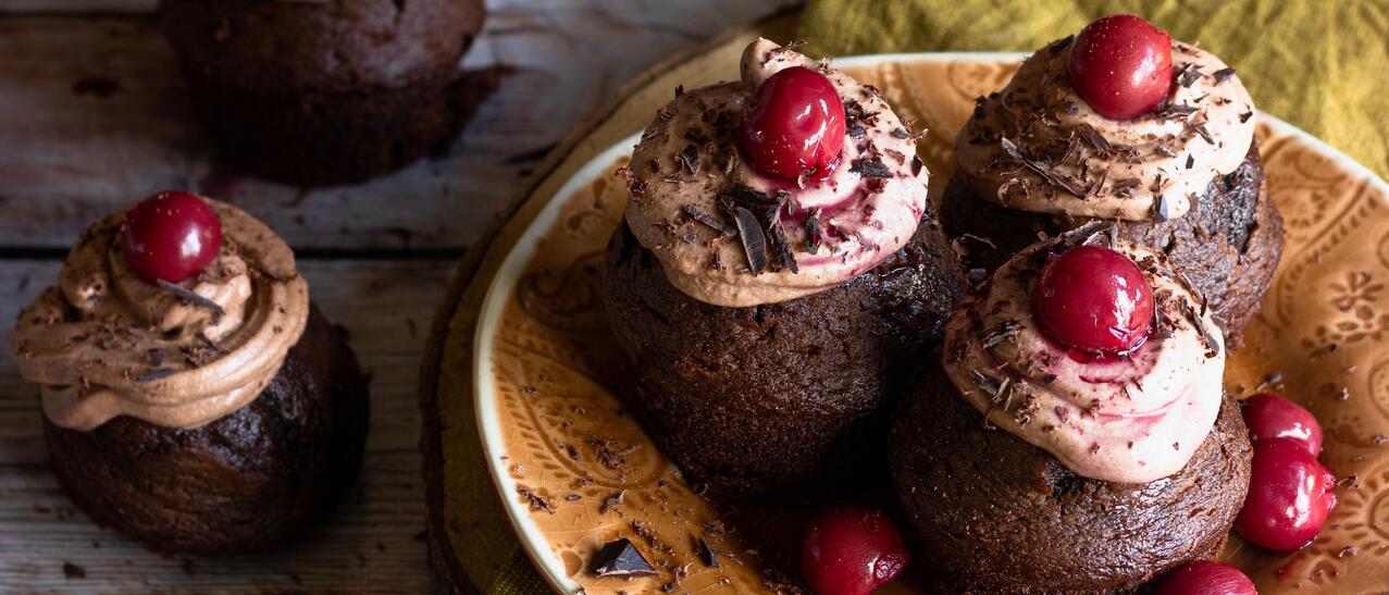 Main d'une femme qui ajoute la garniture à un dessert au chocolat.