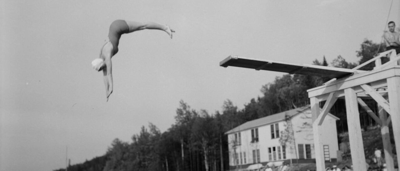 Vue noir et blanc d'une femme plongeant dans un lac.