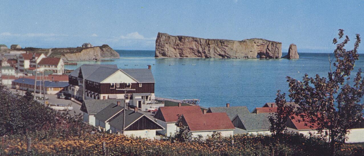 Paysage mettant de l'avant la ville de Percé et le rocher percé, à l'horizon.