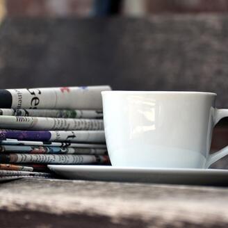 Tasse et pile de journaux.